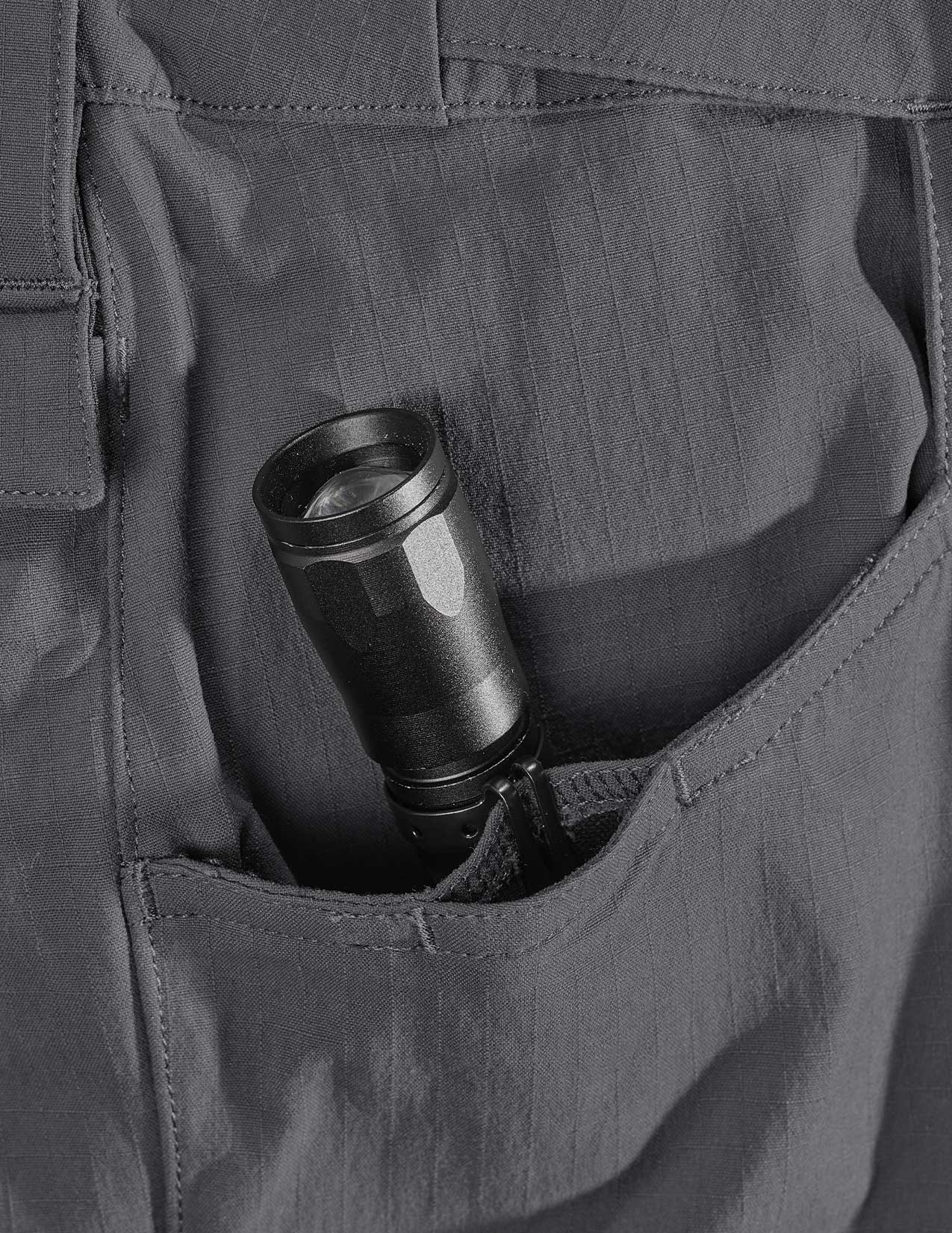 Black flashlight in a pocket of gray pants