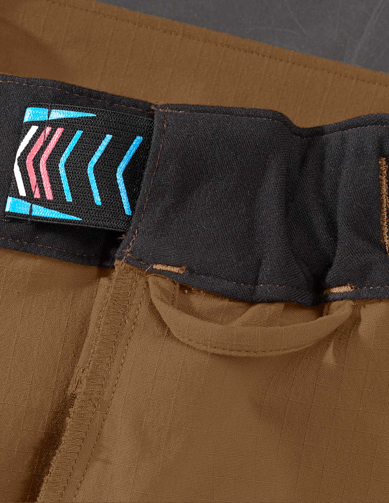 Close-up of brown pants showing a loop for suspenders