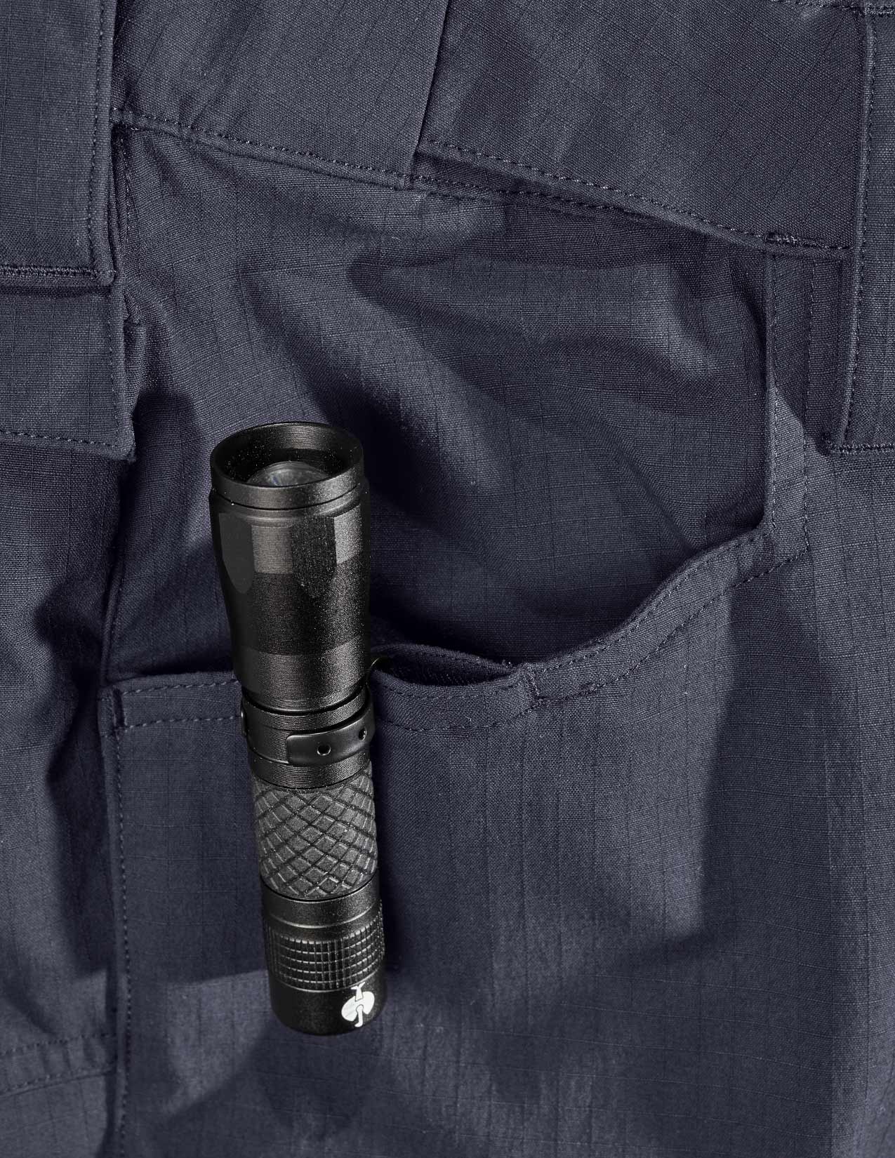 Black flashlight in a pocket of dark blue pants