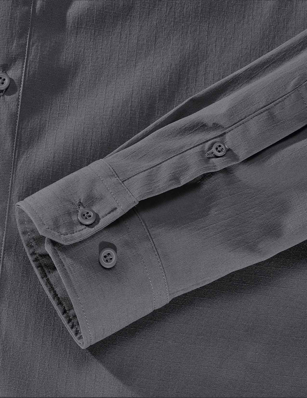 Close-up of a gray shirt with rolled-up sleeve and buttons.