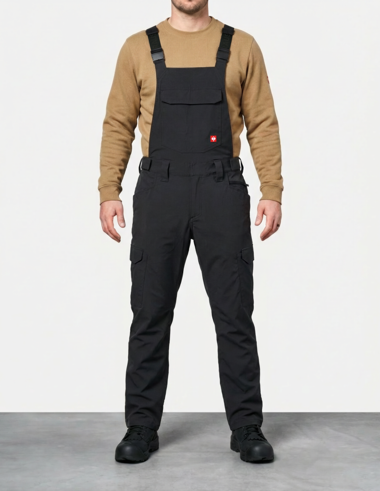a man wearing black bib overalls on a white background