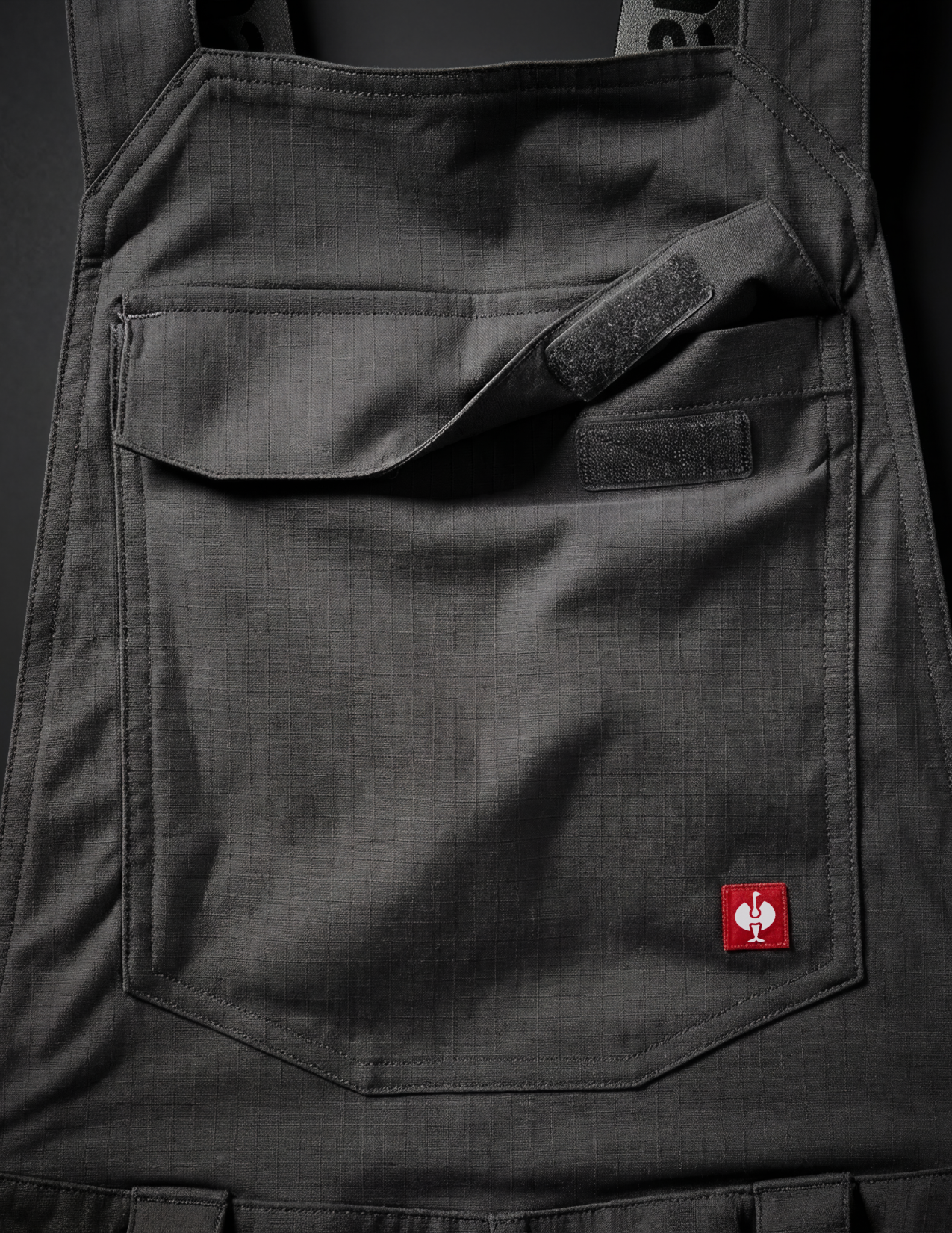 close-up of the front pocket of the black bib with the brand logo on it