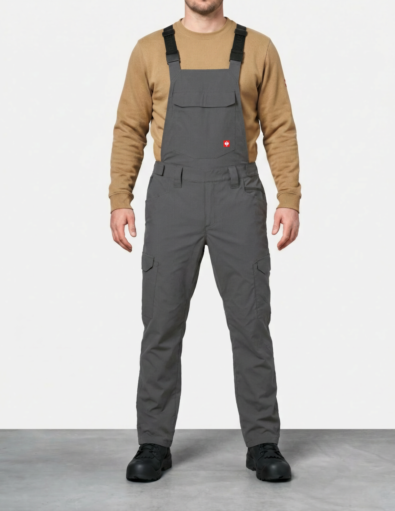 a man wearing gray bib overalls on a white background