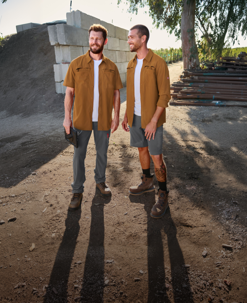 Two men standing on a construction site wearing workwear