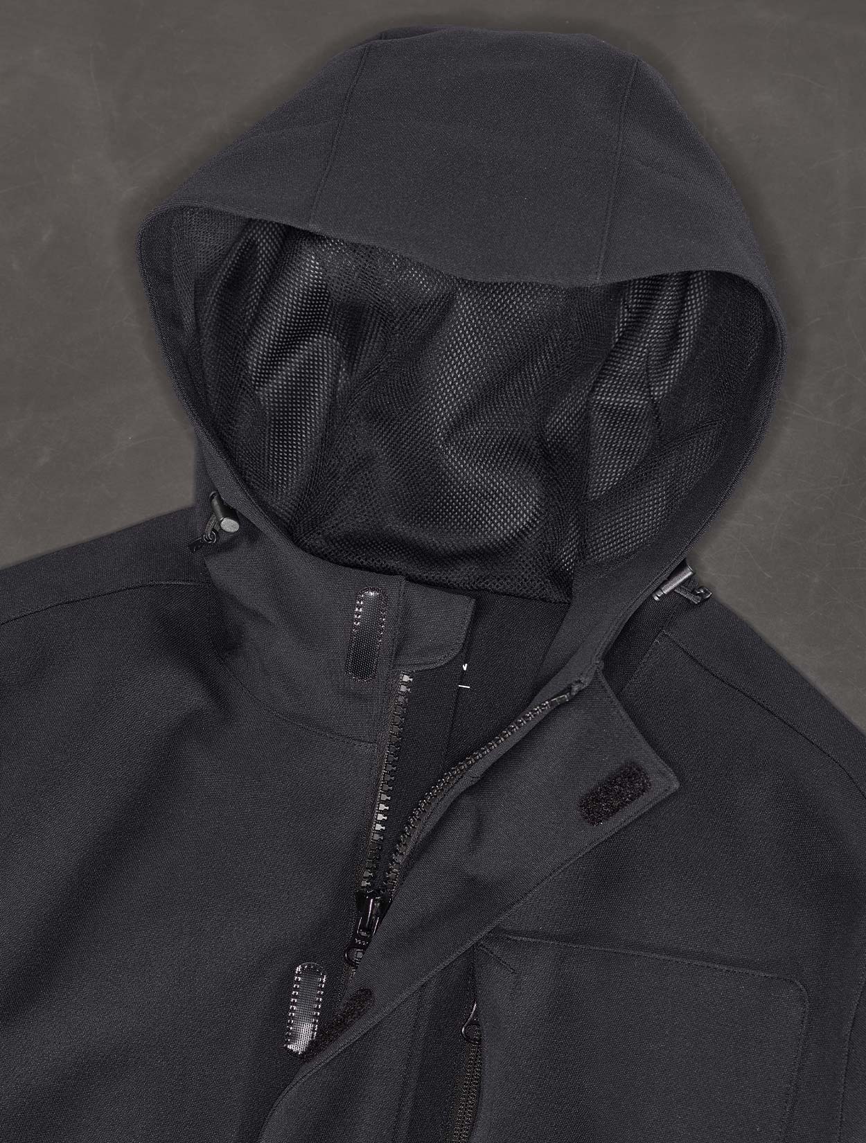 Black hooded jacket with a textured hood against a dark background