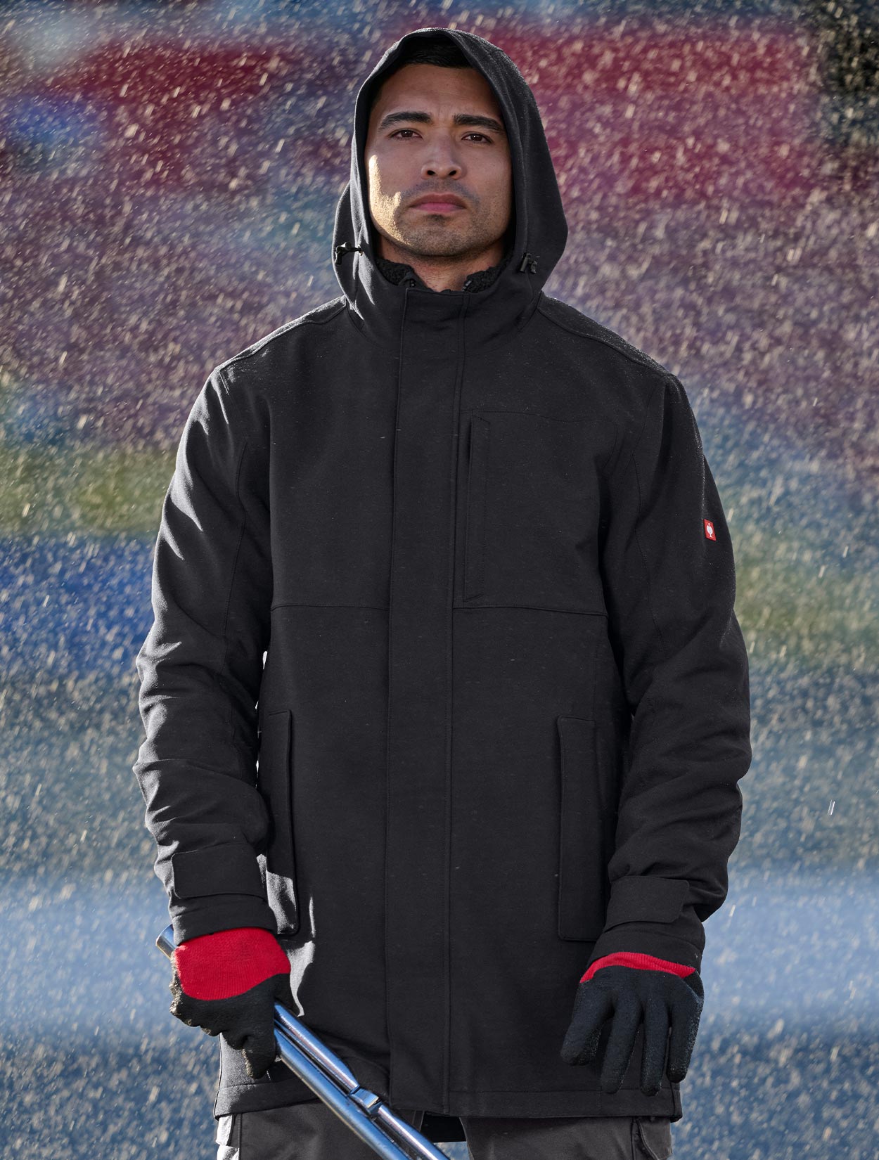 Person wearing a black jacket  in front of a colorful abstract background
