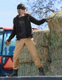 Person working with hay bales near a tractor on a farm