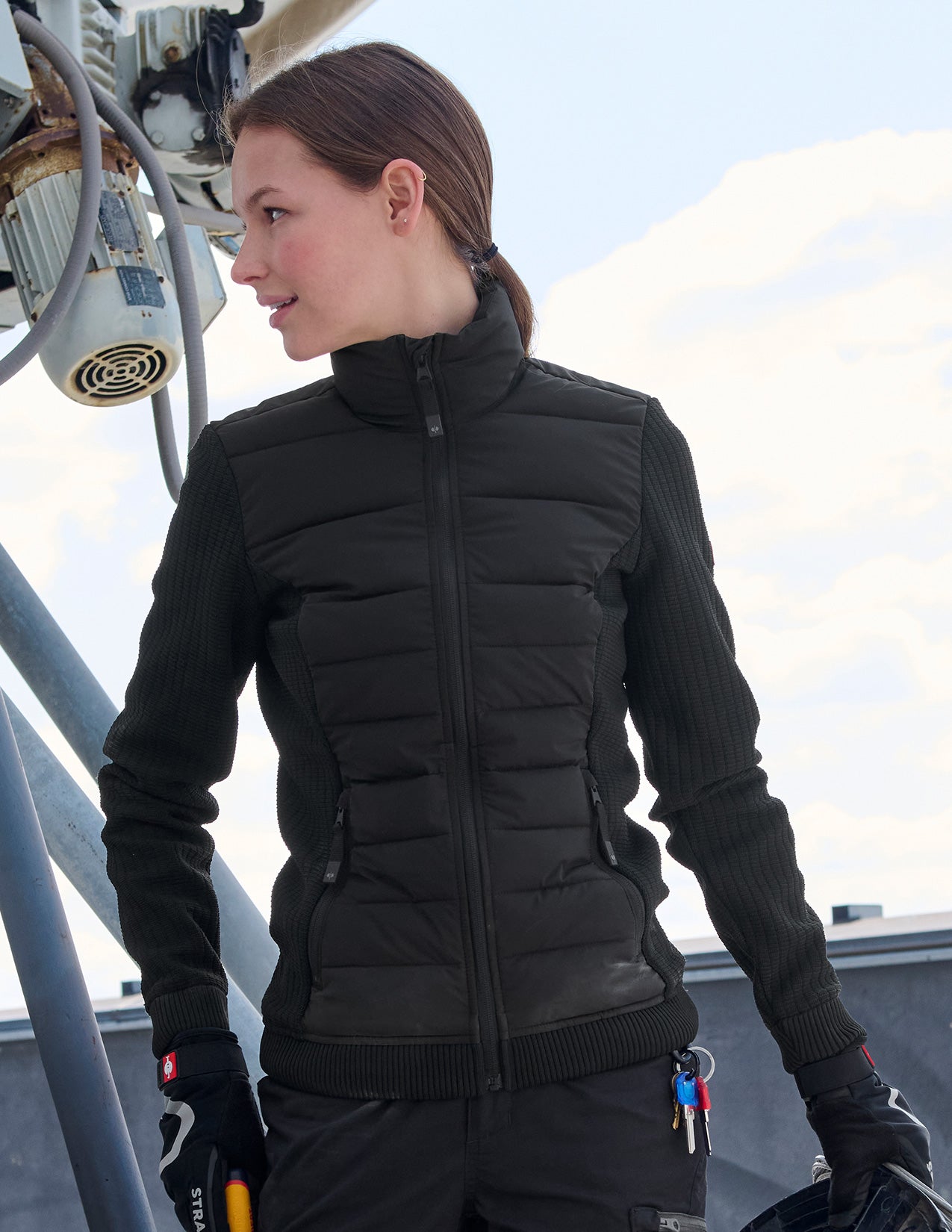 Person wearing a black puffer jacket on a rooftop.