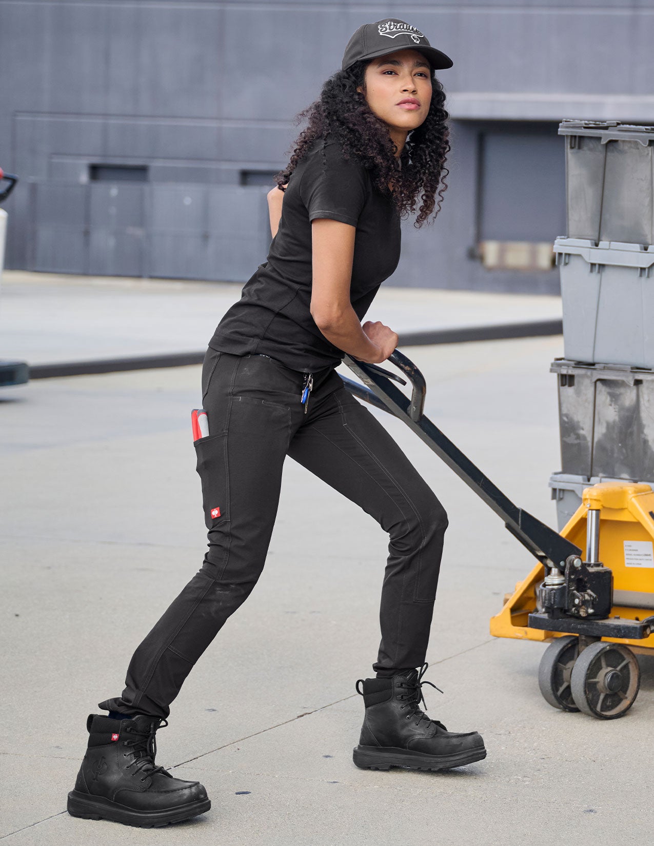 Person pushing a hand truck in an industrial setting