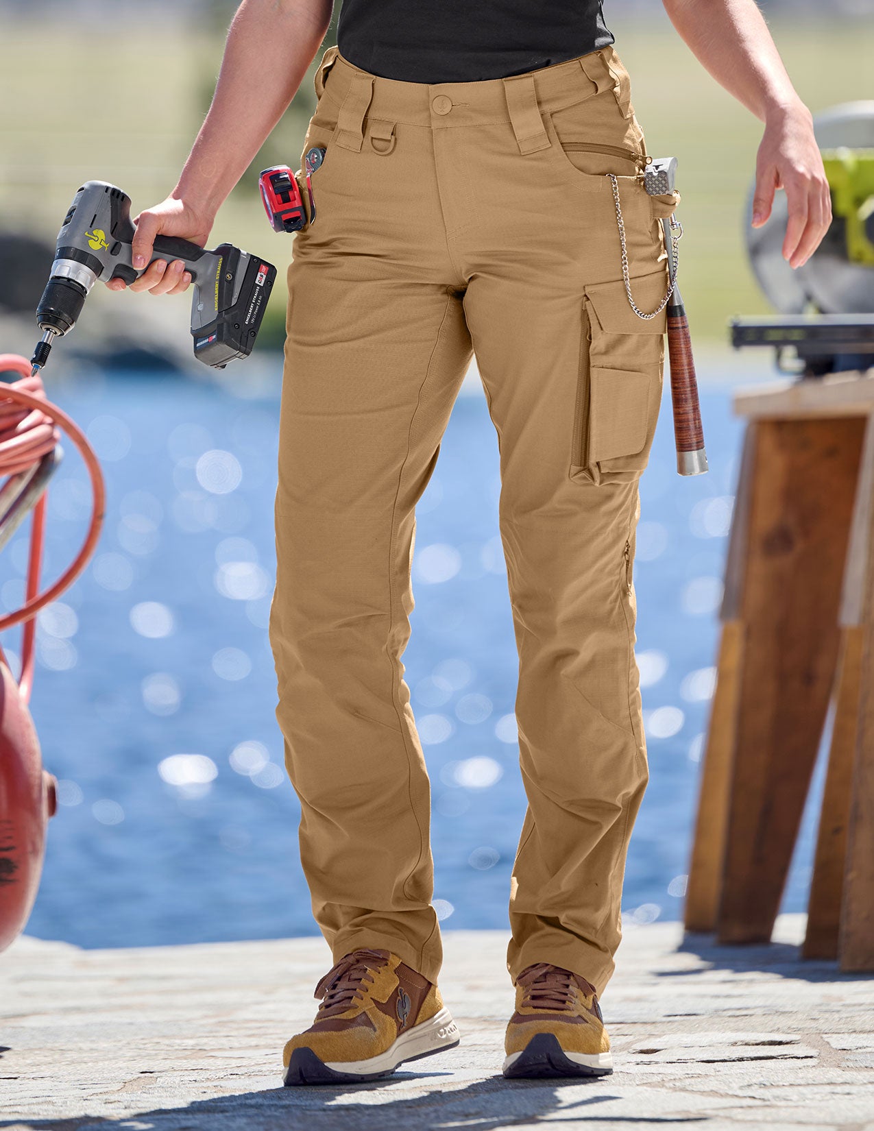 Person wearing tan work pants with tools on a dock