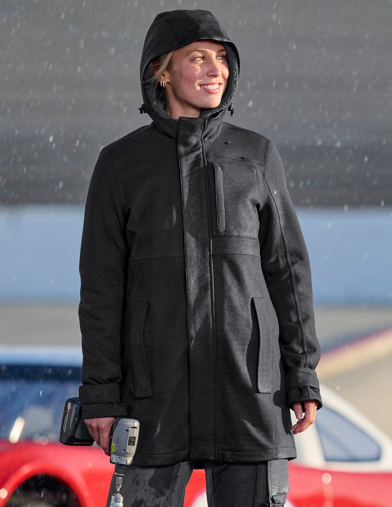 Woman wearing a black coat standing outdoors in the rain