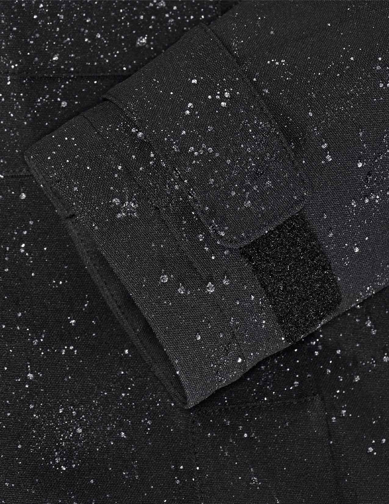 Close-up of black fabric with raindrops on a dark background