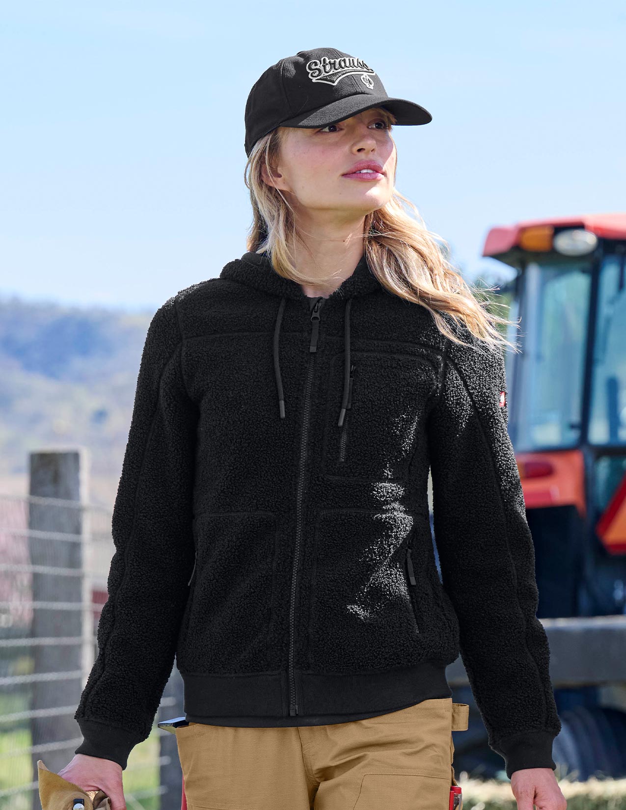 Person wearing a black hoodie and cap with a blurred background