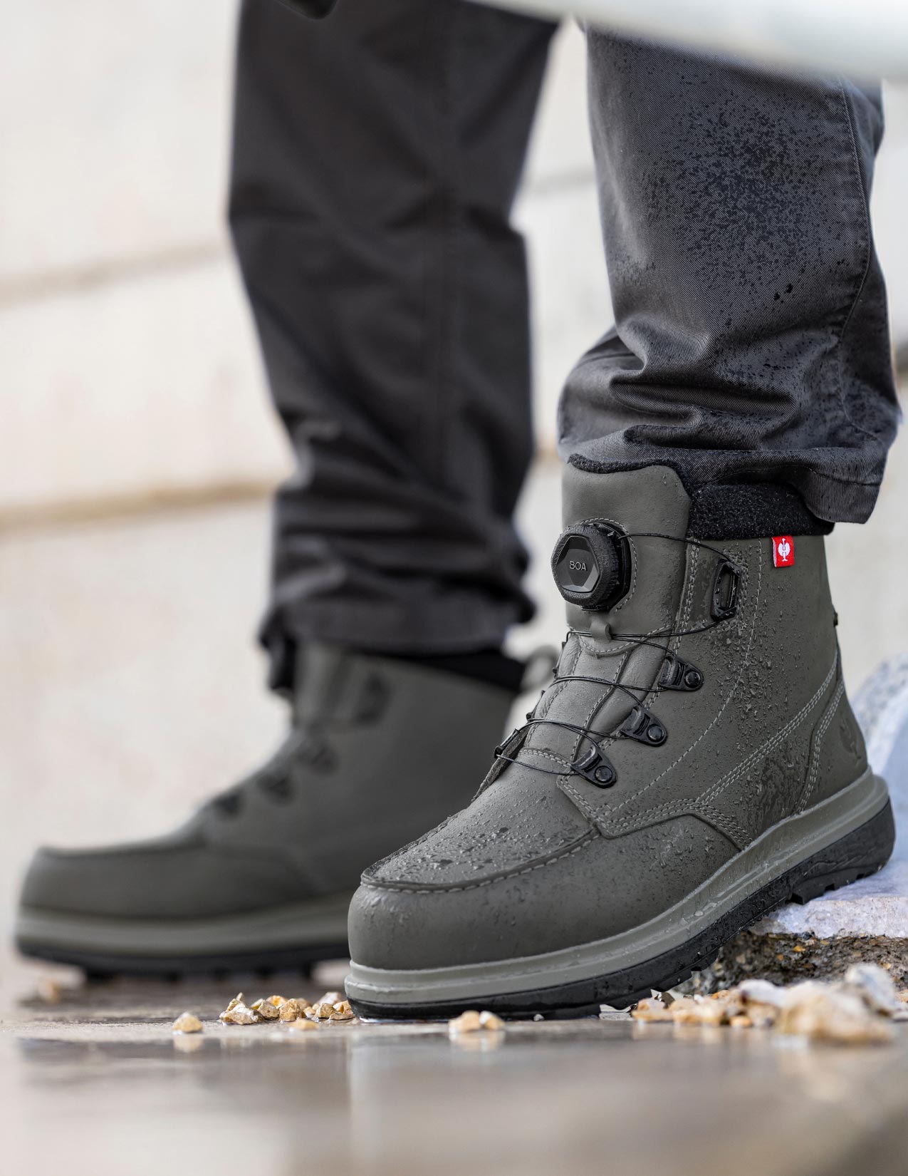 Carbongray winter boots with a Strauss logo on a snowy ground