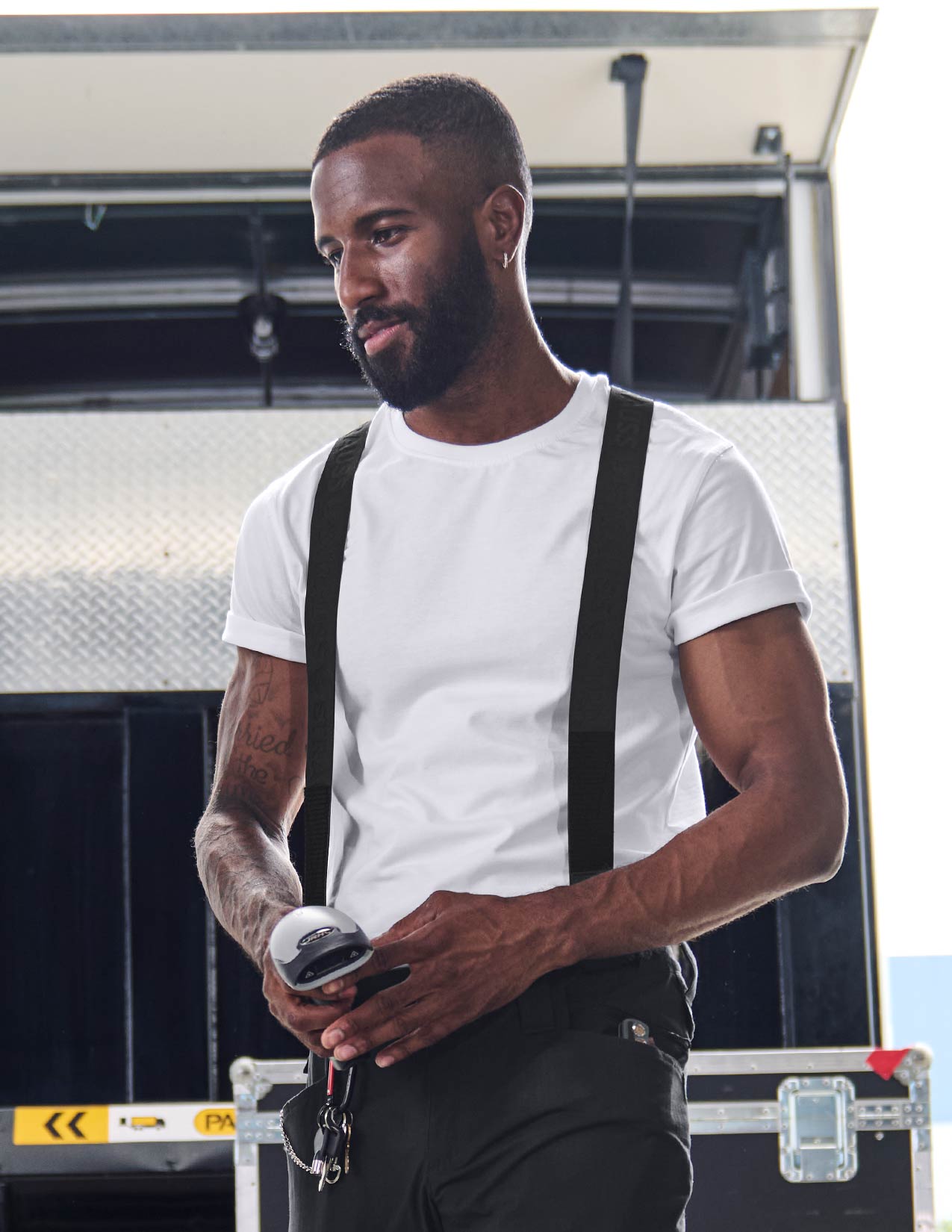a man wearing suspenders over a white T-shirt