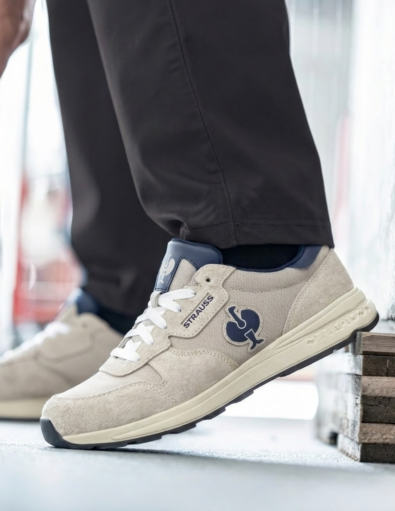 Beige sneakers with a logo worn by a person, blurred background