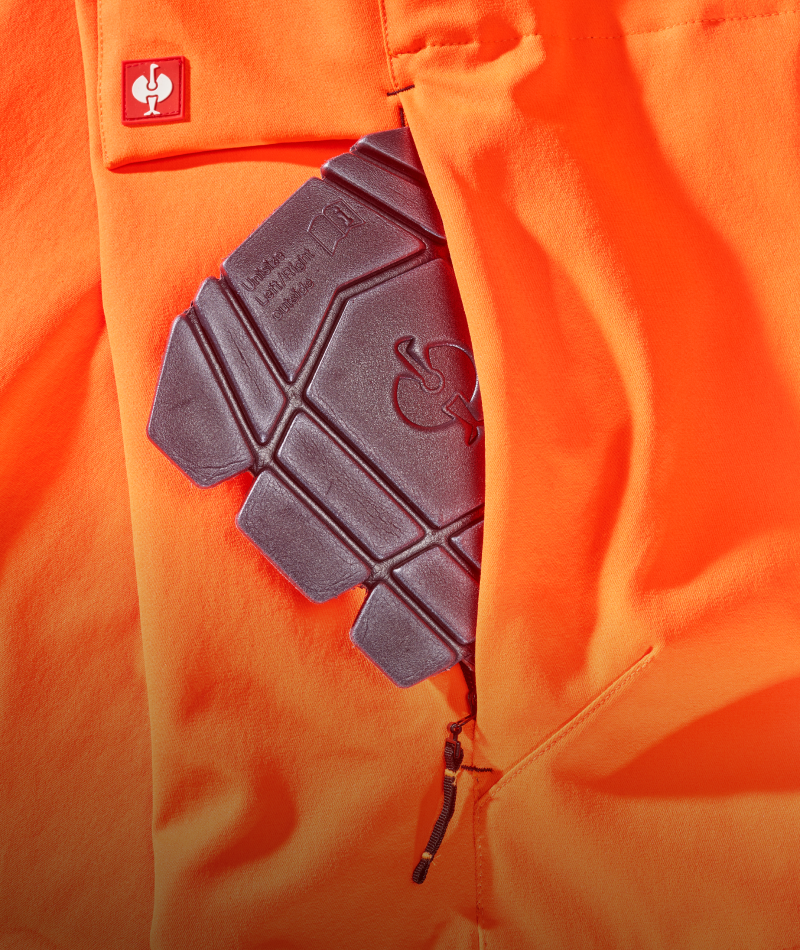 A worker wears STRAUSS High Visibility Work Pants with work boots in a jobsite outfit.