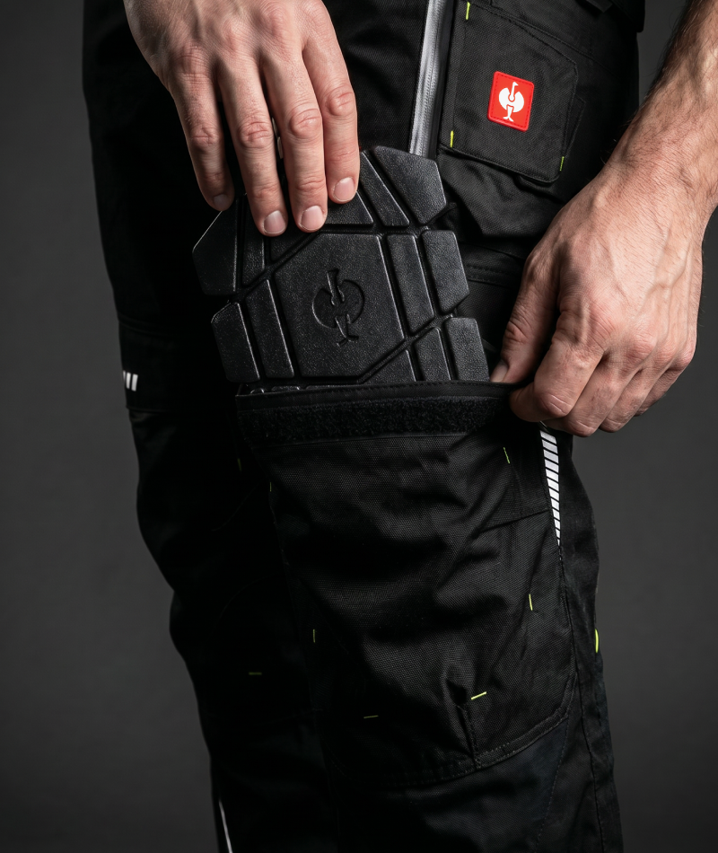 A worker wears STRAUSS e.s.motion 2020 Cargo Work Pants with work boots in a jobsite outfit.