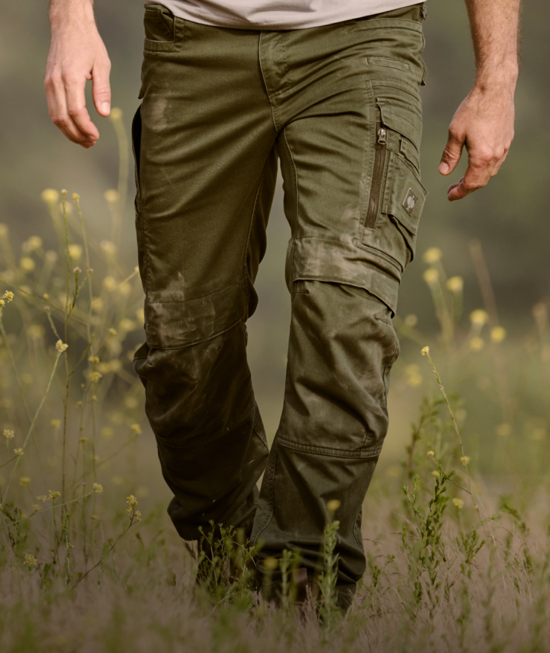 A worker wears STRAUSS e.s.motion ten Cargo Work Pants with work boots in a jobsite outfit.