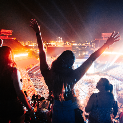 a woman raising her hands, dancing to the music