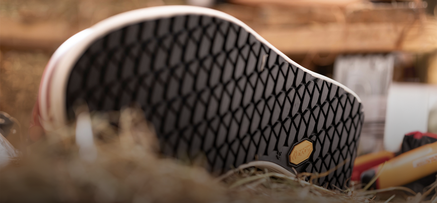 Close-up of a black and white patterned shoe with a gold tag on a blurred background