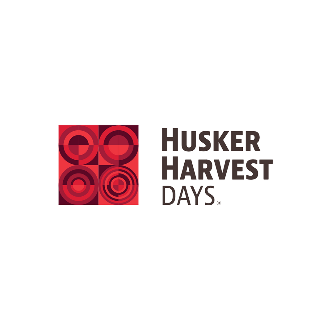 Husker Harvest Days logo with red geometric design on a white background