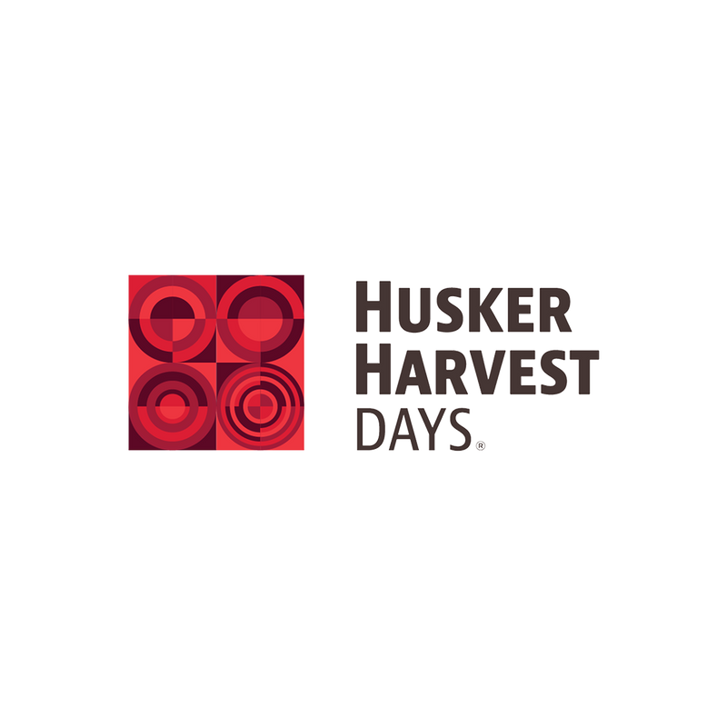Husker Harvest Days logo with red geometric design on a white background
