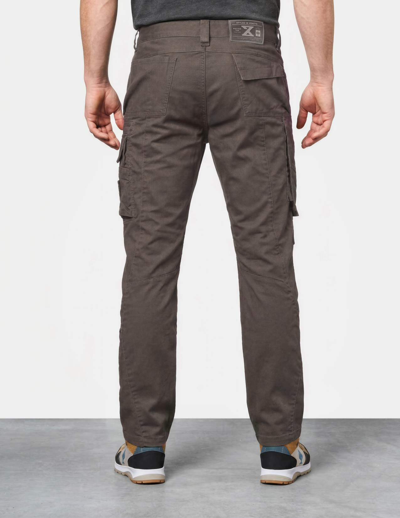 Person wearing brown cargo pants on a plain background