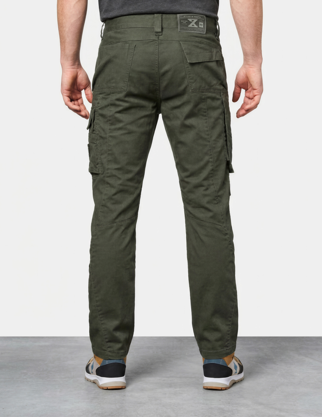 Person wearing green cargo pants on a plain background