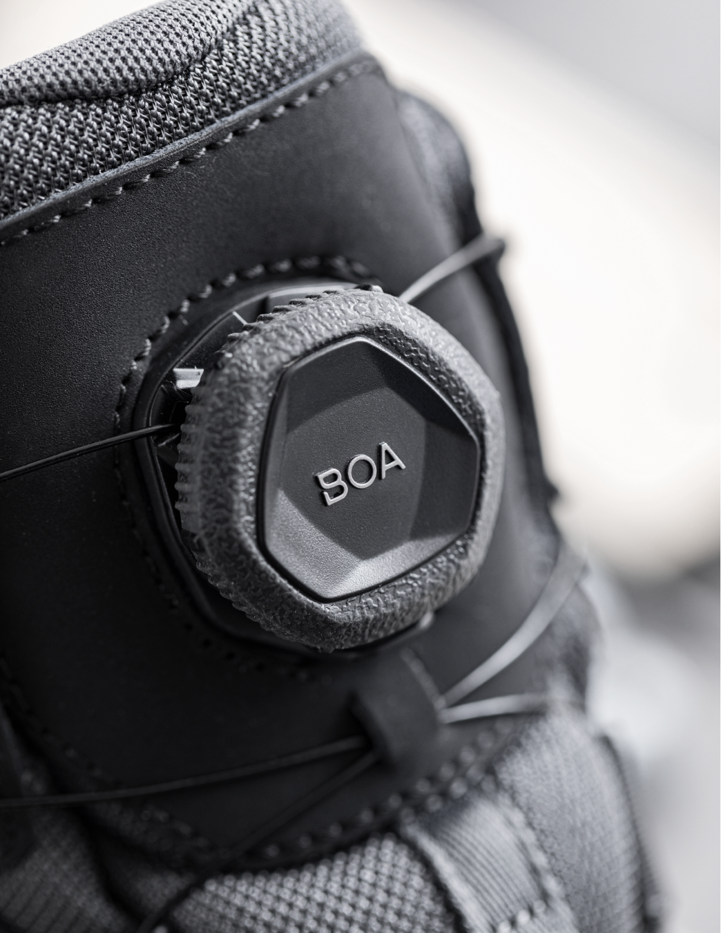 Close-up of a BOA system on a carbon grey shoe with a blurred background