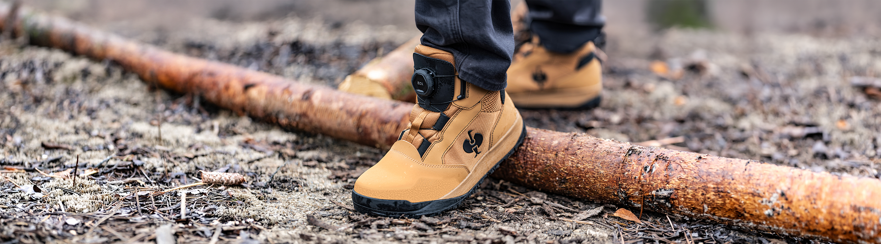 A person wearing Murcia Work Boots in a wet forest environment. The special focus is on the BOA closure system.