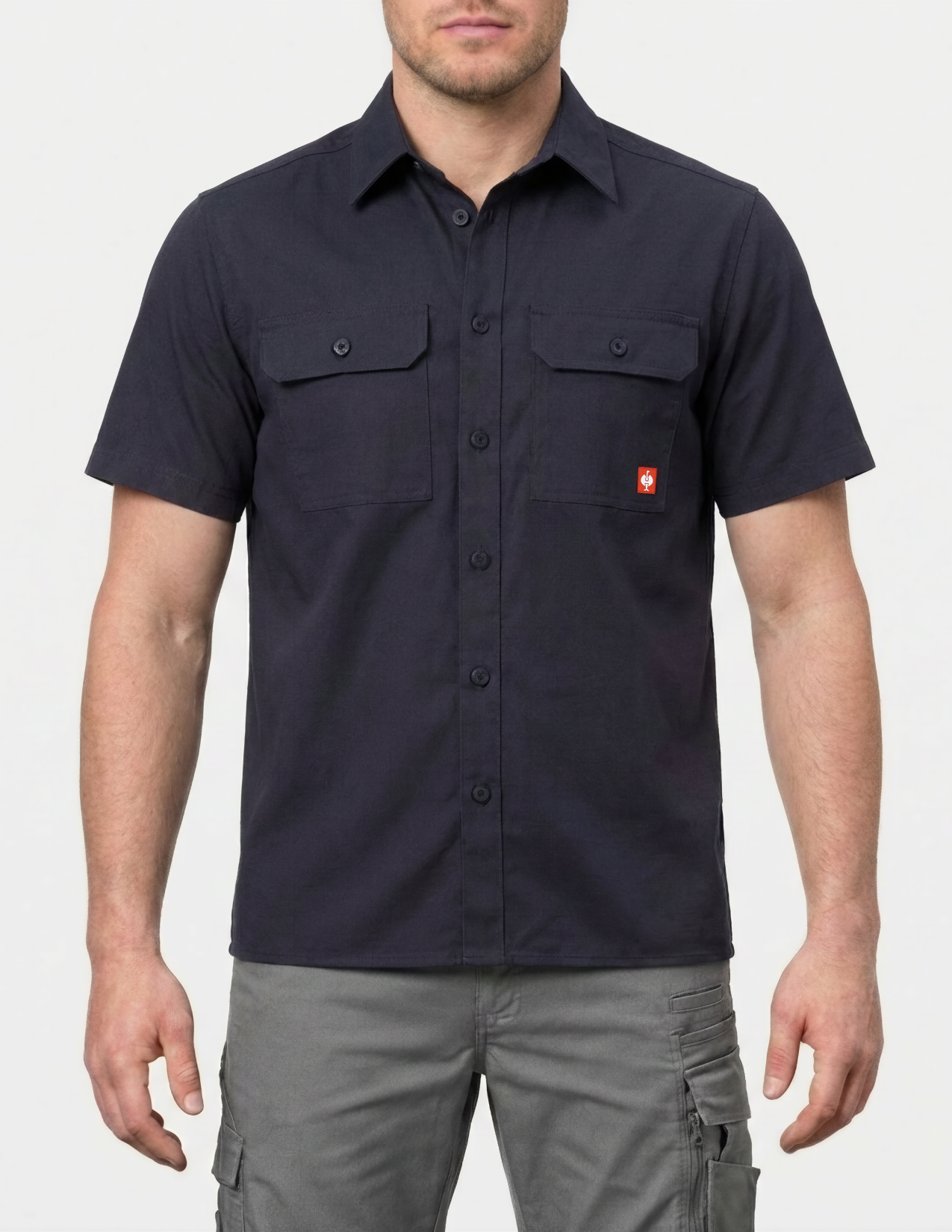 Man wearing a navy work shirt with a red brand logo on a white background