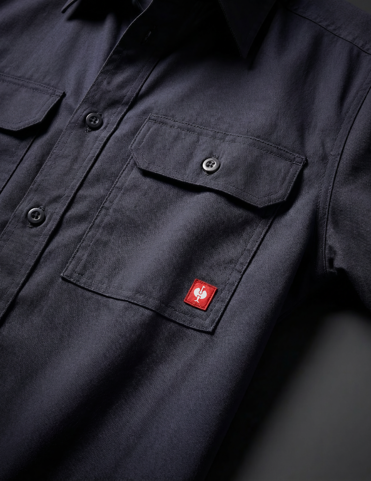 navy work shirt with a red brand logo on the chest pocket