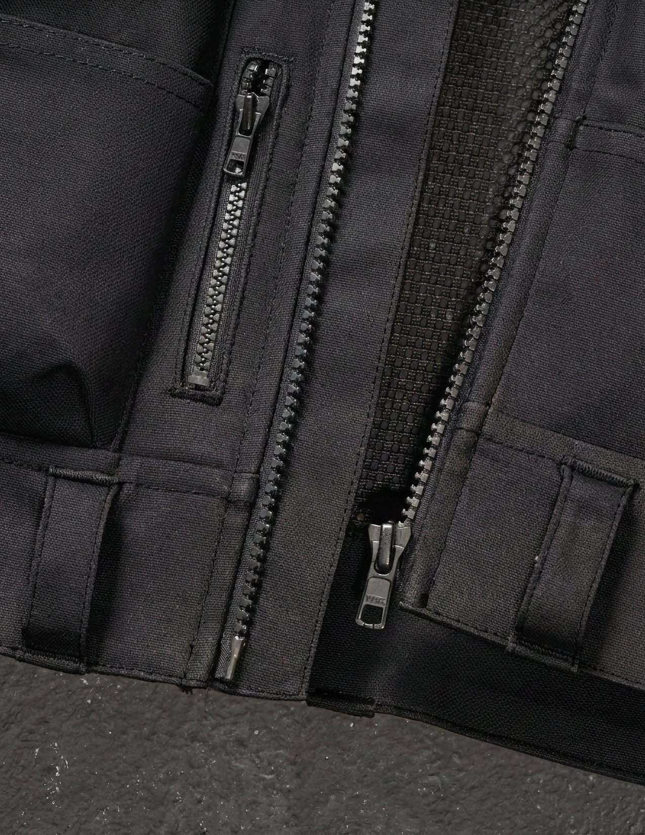 Close-up of a black vest with zippers and pockets