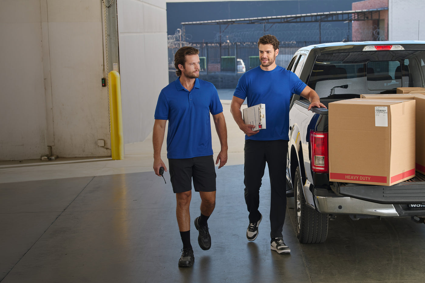 two workers get boxer from the back of their truck